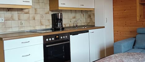 Een koelkast, een oven, een kookplaat, een koffiezetapparaat/waterkoker