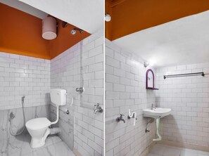 A bathroom with white tiled walls, a white toilet, a sink, and a shower area. - iROOMZ Hotel Anandalok (Barasat)