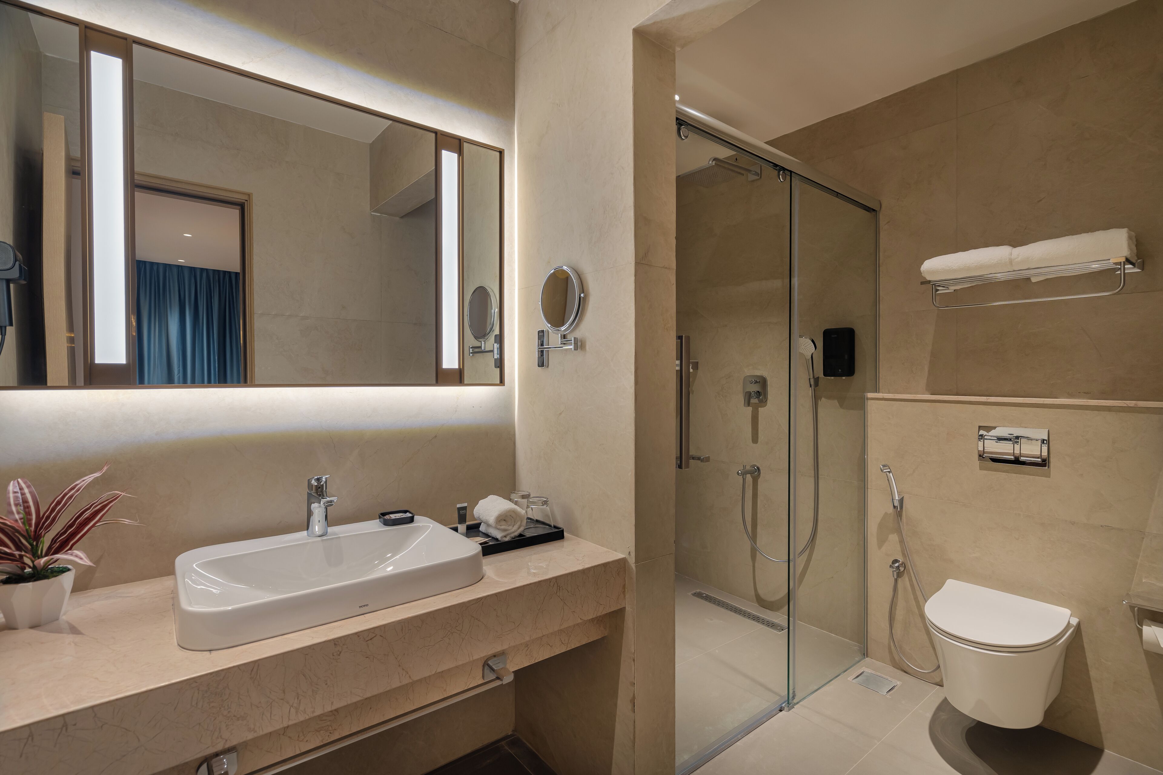 A modern bathroom with a sink, mirror, and shower.