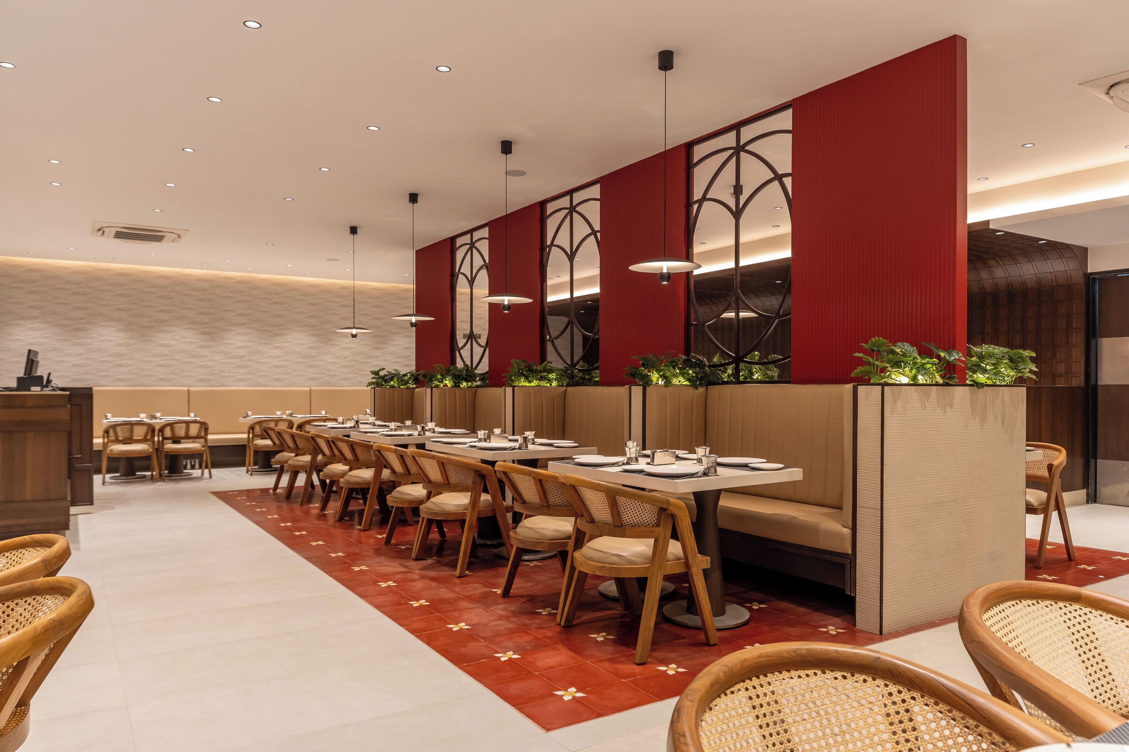 Un restaurant moderne doté de longues tables conviviales, de banquettes confortables et de chaises en osier.