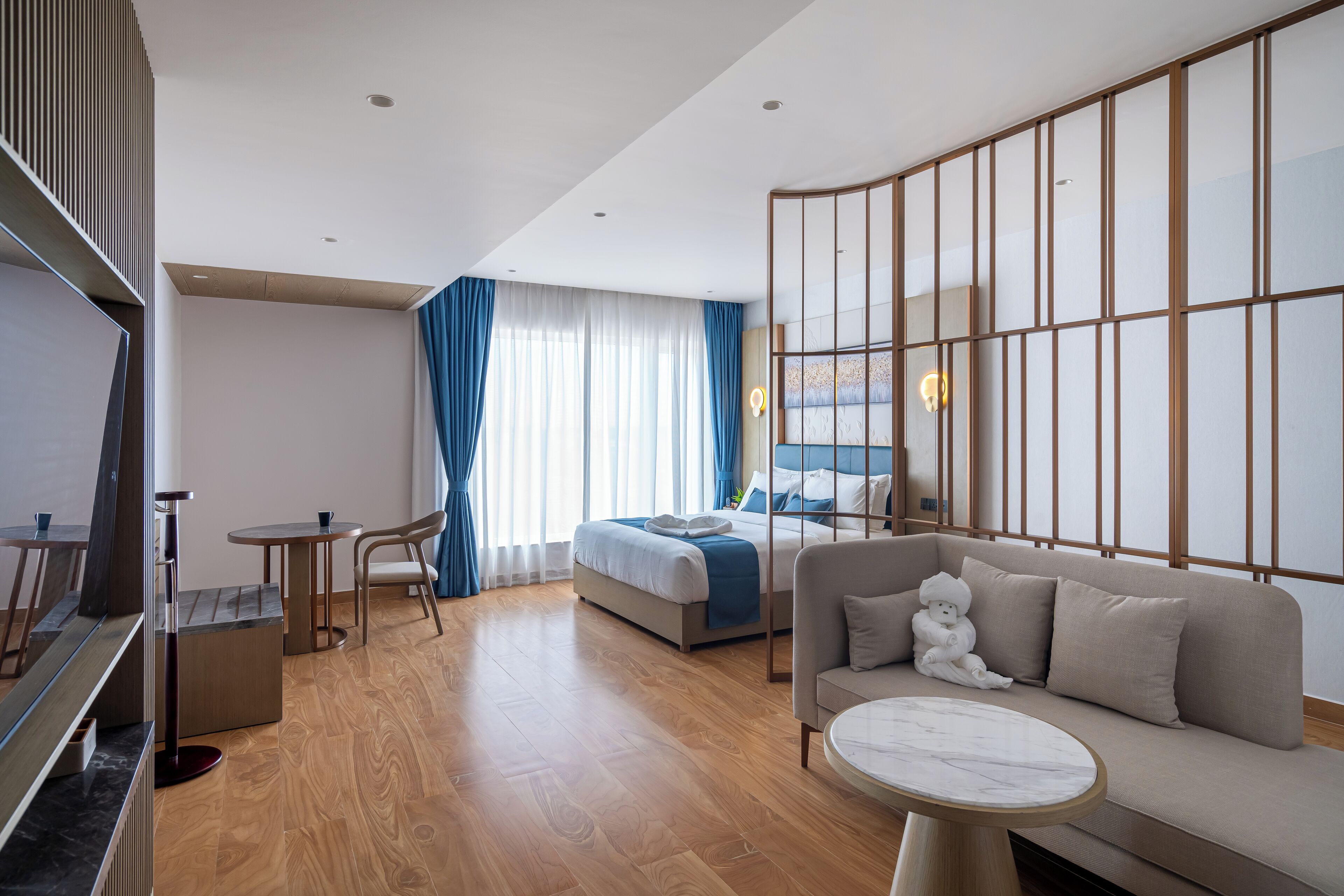 Ein modernes Hotelzimmer mit Bett, Sofa und einem kleinen Tisch.