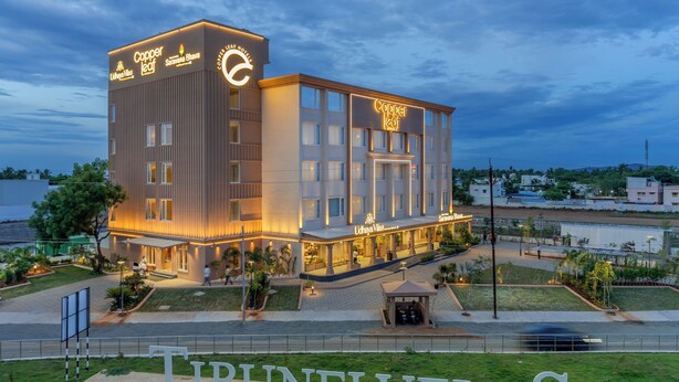 A modern hotel with a prominent 'Copper Leaf' sign, featuring a clean, contemporary design with large windows and a well-lit facade. - Copper Leaf Hotels, Tirunelveli (Palayankottai)