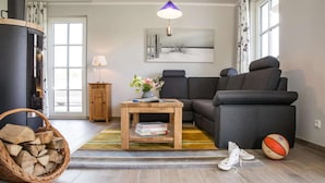 En stue med sofa, sofabord, pejs, lampe og et vindue.