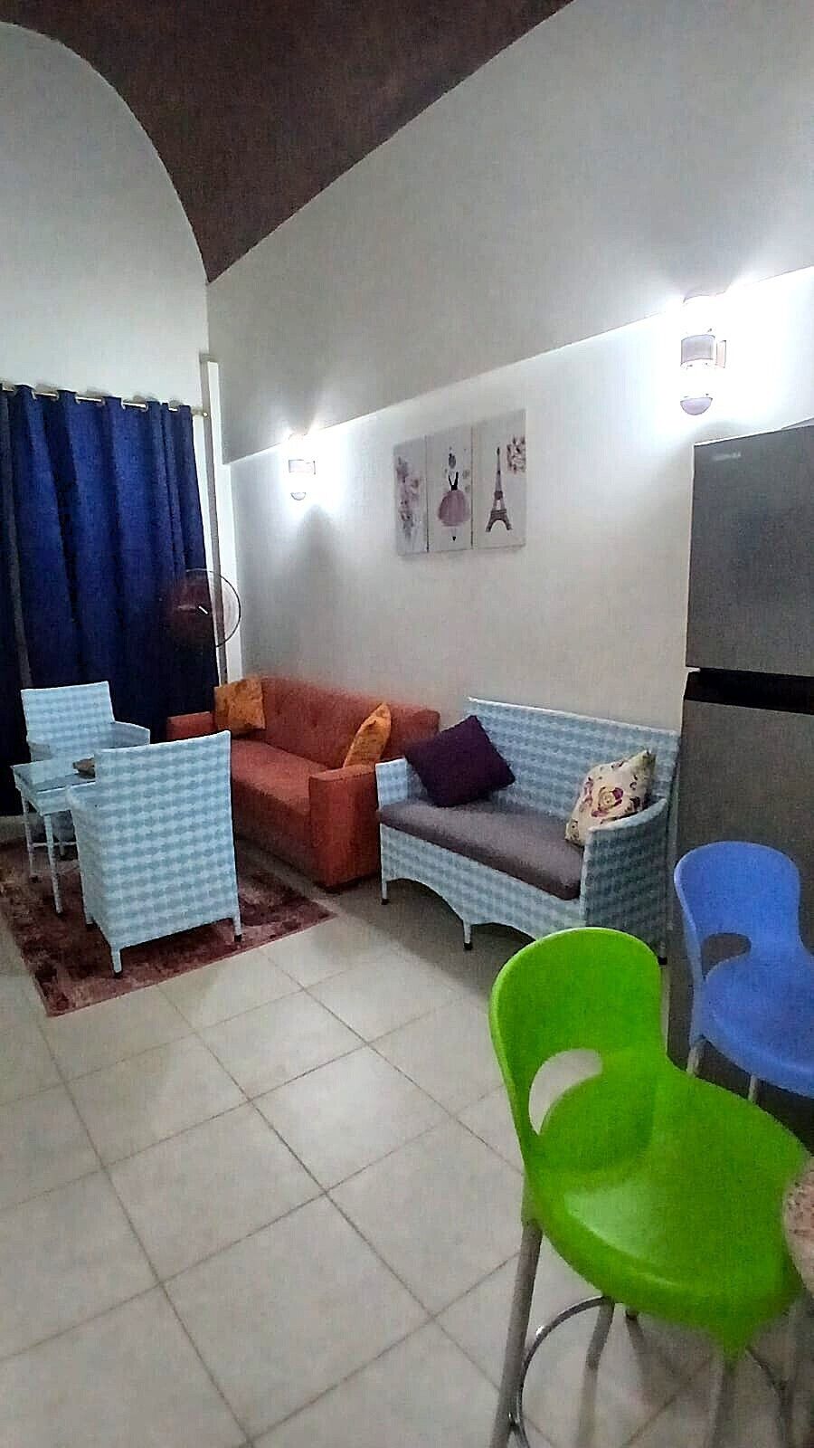 Una sala de estar con un sofá, dos sillones, una mesa de centro y un televisor.