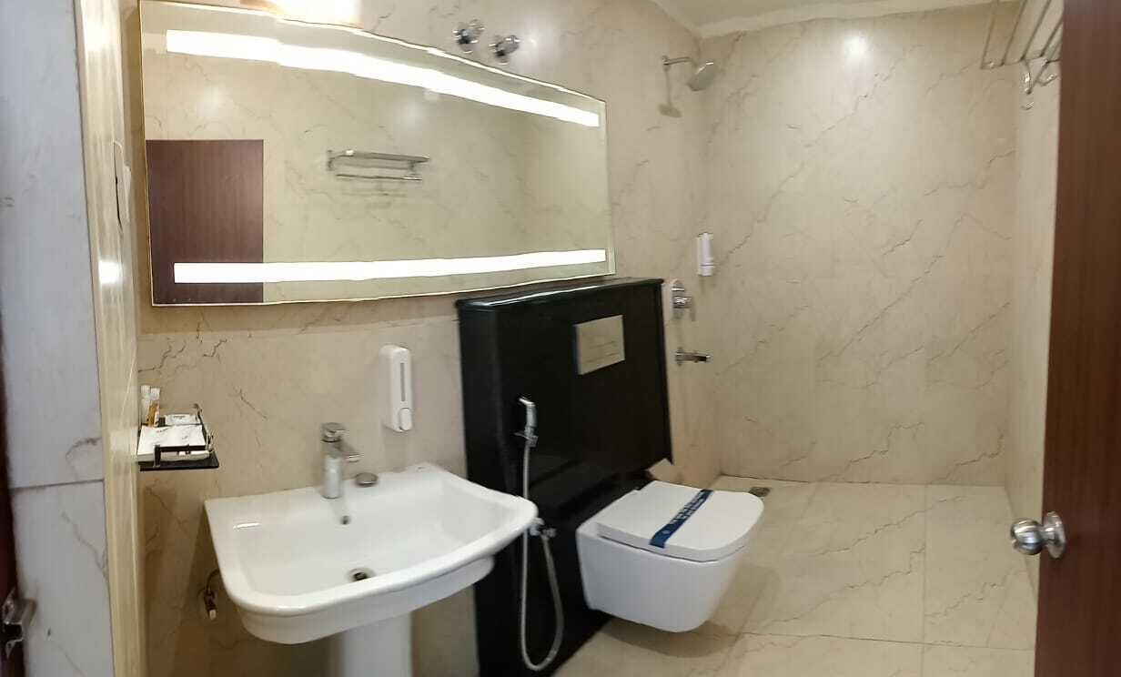 Een badkamer met een wastafel, spiegel en douche.
