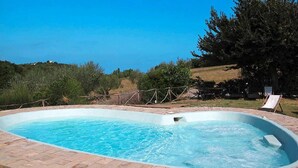 A rectangular swimming pool with a brick border, surrounded by a grassy area and trees. - Casa Mare Holiday in Vallugola (Vallugola)
