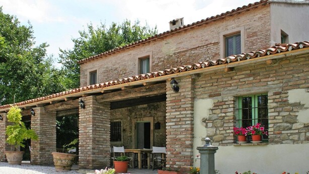 A rustic stone building with a covered patio, outdoor seating, and potted plants. - Casa Mare Holiday in Vallugola (Vallugola)