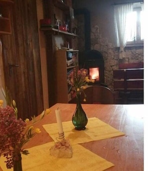 Una mesa de comedor con un florero, una vela y una servilleta.