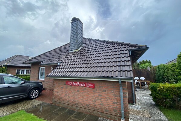 A brick building with a tiled roof and a chimney. A sign on the building reads "Bus Renate."