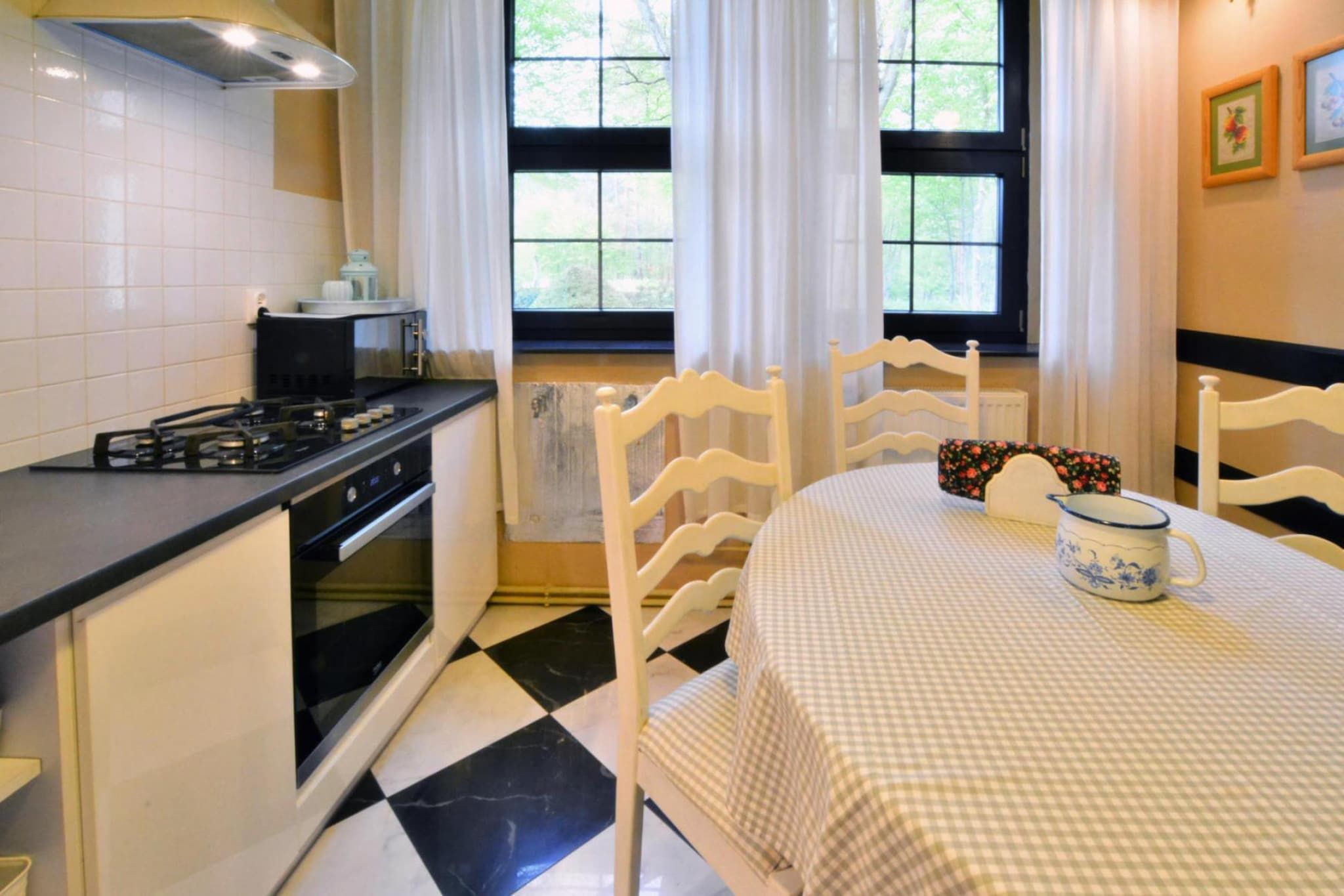 Une cuisine équipée d’une cuisinière, d’un four et d’une table à manger avec des chaises.