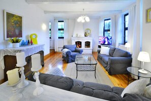 A living room with a fireplace, two sofas, a coffee table, and a television. - Large holiday villa with fireplace and garden (Polanow)