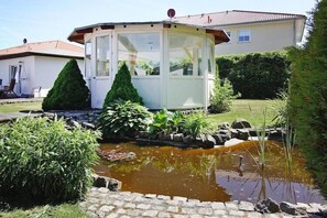 Escape to a serene oasis surrounded by lush greenery and a tranquil pond.