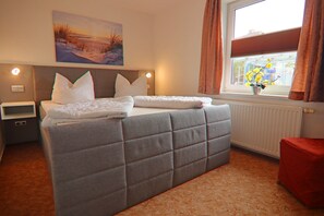 Relax in comfort with a large bed, a cozy table, and a beautiful view.