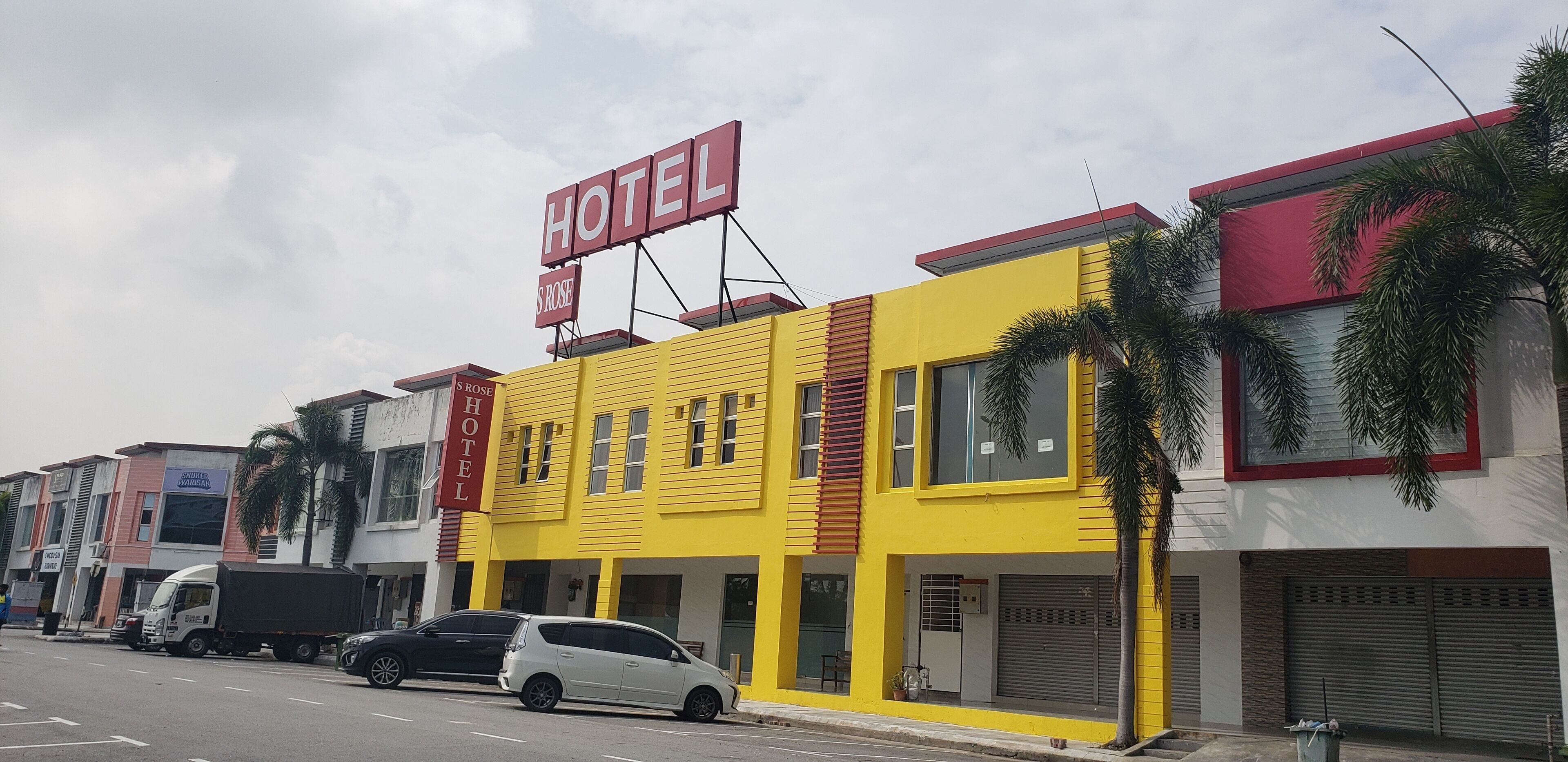 A yellow building with a sign that reads "HOTEL ROSE".