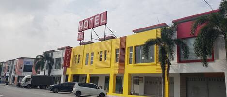 A yellow building with a sign that reads "HOTEL ROSE".