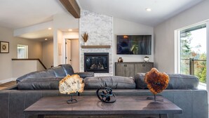 A modern living room with a fireplace, leather sofas, and a large TV. - Panoramic Paradise (Yosemite National Park)