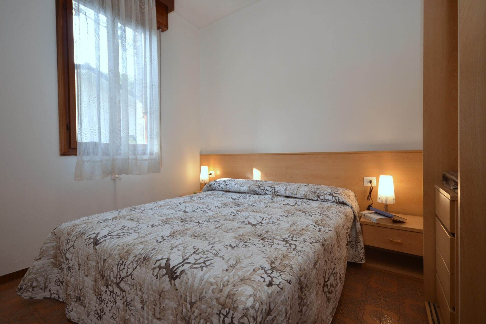 Une chambre à coucher avec un lit, des lampes de chevet, une table de chevet et une armoire.