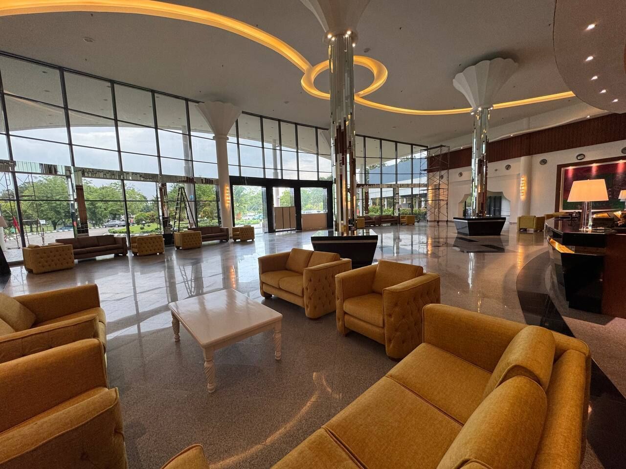 A spacious lobby with large windows, a pool table, and comfortable seating areas.