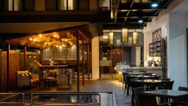 An indoor dining area with tables and chairs, a small pool, and a warm, inviting atmosphere with string lights. - Laska Hotel Sukabumi (Sukabumi)