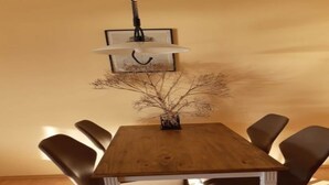 Un tavolo da pranzo con sei sedie, un lampadario a sospensione e un quadro appeso al muro.