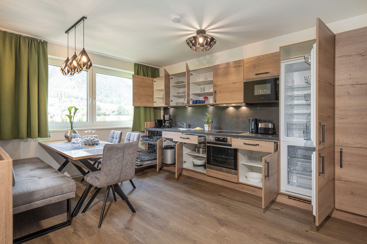 Eine moderne Küche mit Holzausstattung, einem eingebauten Ofen und einem großen Fenster.