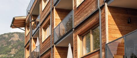 Un edificio de varios pisos con fachada de madera y ventanas amplias.