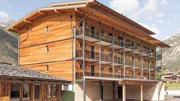 A multi-story wooden building with balconies and a covered entrance area.