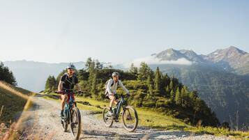 Due ciclisti su un sentiero di montagna con una vista aperta sul paesaggio circostante.