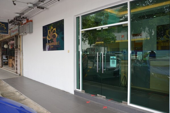 A building with a reception area, glass doors, and a sign for 'Signature'. - Signature Inn (Kota Kinabalu)