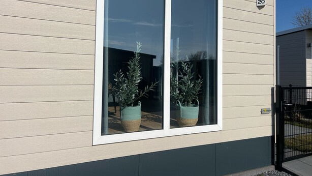 Un bâtiment moderne doté d’une grande fenêtre et d’un petit balcon.