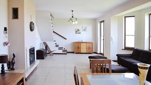 Un salon spacieux avec un escalier, un coin repas et un canapé.