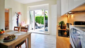 A modern kitchen with a microwave, a sink, and a dining area with a table set for two.