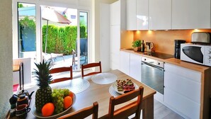 A modern kitchen with white cabinets, a microwave, and a dining area with a table set for two.