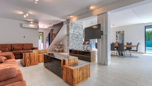 A spacious living area with a modern sofa, a coffee table, and a TV mounted on the wall. - Vacation home Rial 2 by Interhome (Fažana)