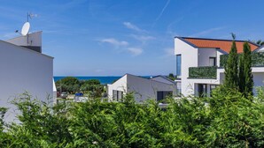 A modern residential area with white buildings, a clear blue sky, and a view of the sea. - Vacation home Rial 2 by Interhome (Fažana)