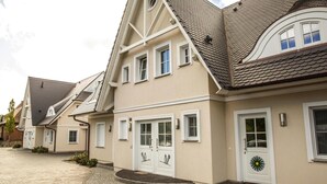 A row of residential houses with pitched roofs, double doors, and small windows. - Wohnung in Zingst nahe Ostseestrand (Zingst)