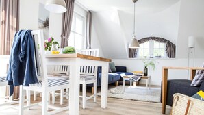 Una sala de estar moderna con comedor, un sofá, una mesa de centro y una lámpara.