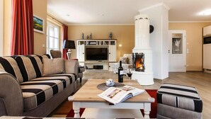 Una sala de estar con sofá, mesa de centro, chimenea y televisor.
