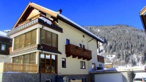 Eine zweistöckige Chalet mit Balkon, großen Fenstern und Garage.