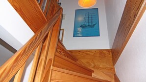A wooden staircase with a ship painting on the wall above. - Apartment in Petersdorf for 6 Personen (Petersdorf)