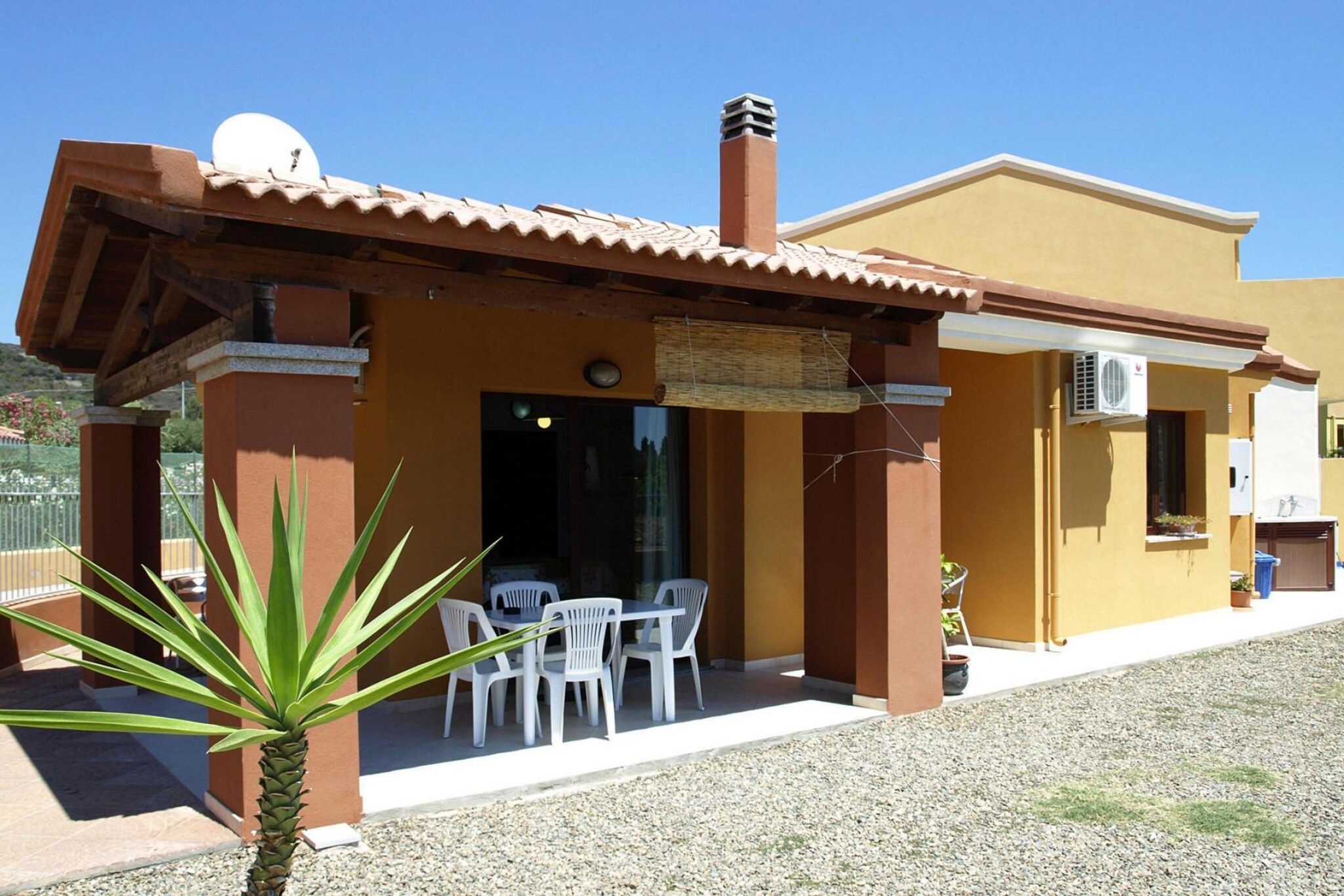 Un bâtiment doté d’un patio couvert, d’un espace extérieur aménagé pour s’asseoir et d’un petit jardin.