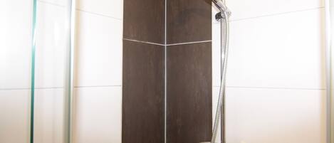 A shower with a handheld showerhead and a handheld shower attachment.