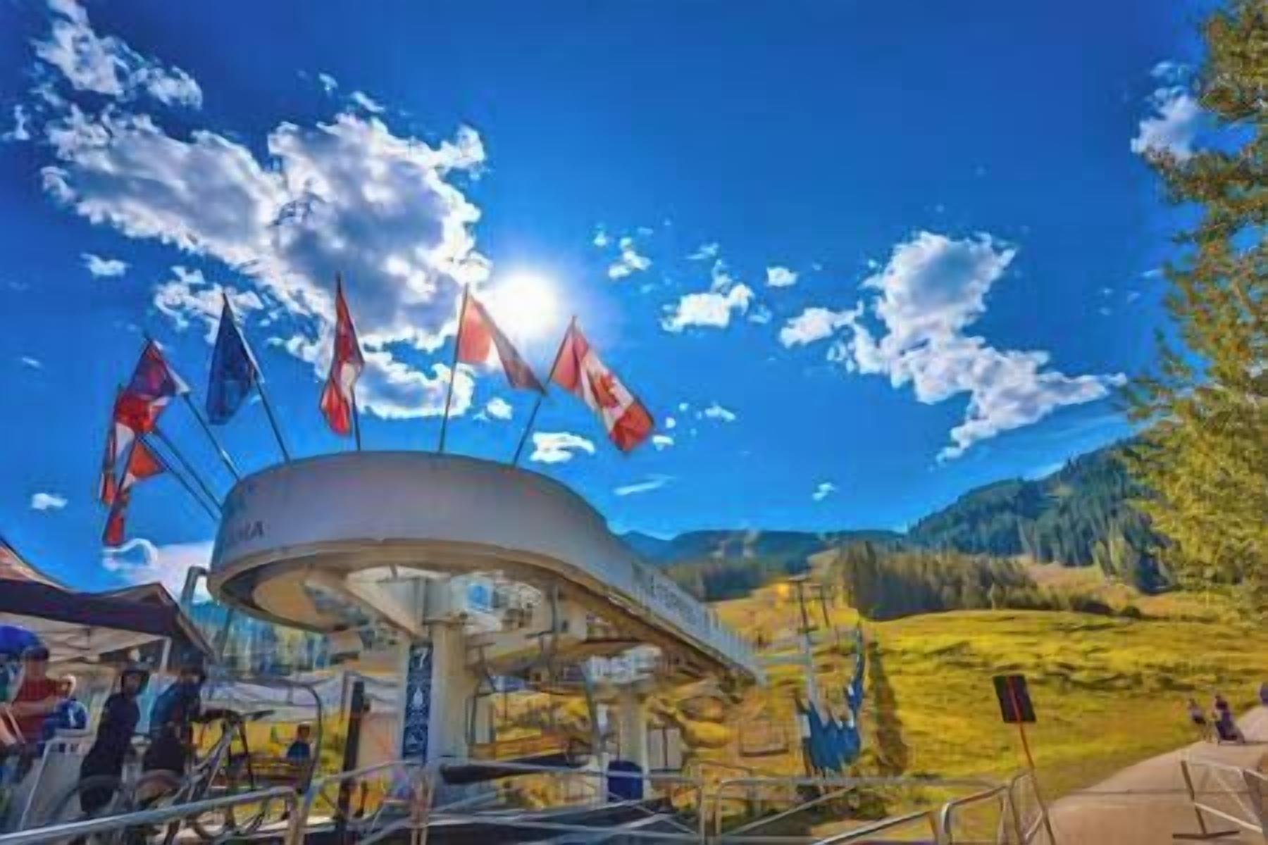 A circular building with flags, surrounded by a mountainous landscape.