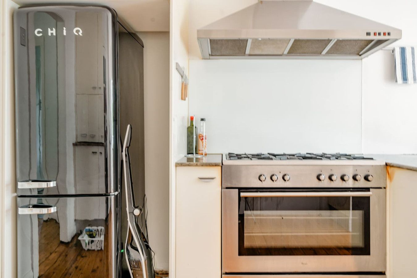 A kitchen with a stainless steel refrigerator, a gas stove, and an oven.