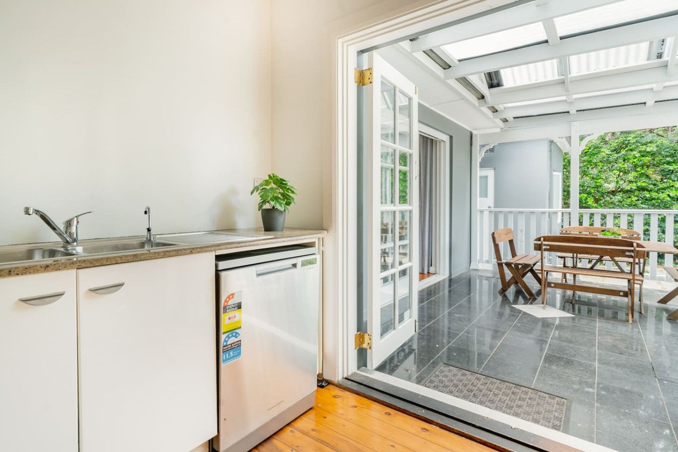 A kitchen with a dishwasher, a sink, and a potted plant.