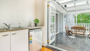 A kitchen with a dishwasher, a sink, and a potted plant.