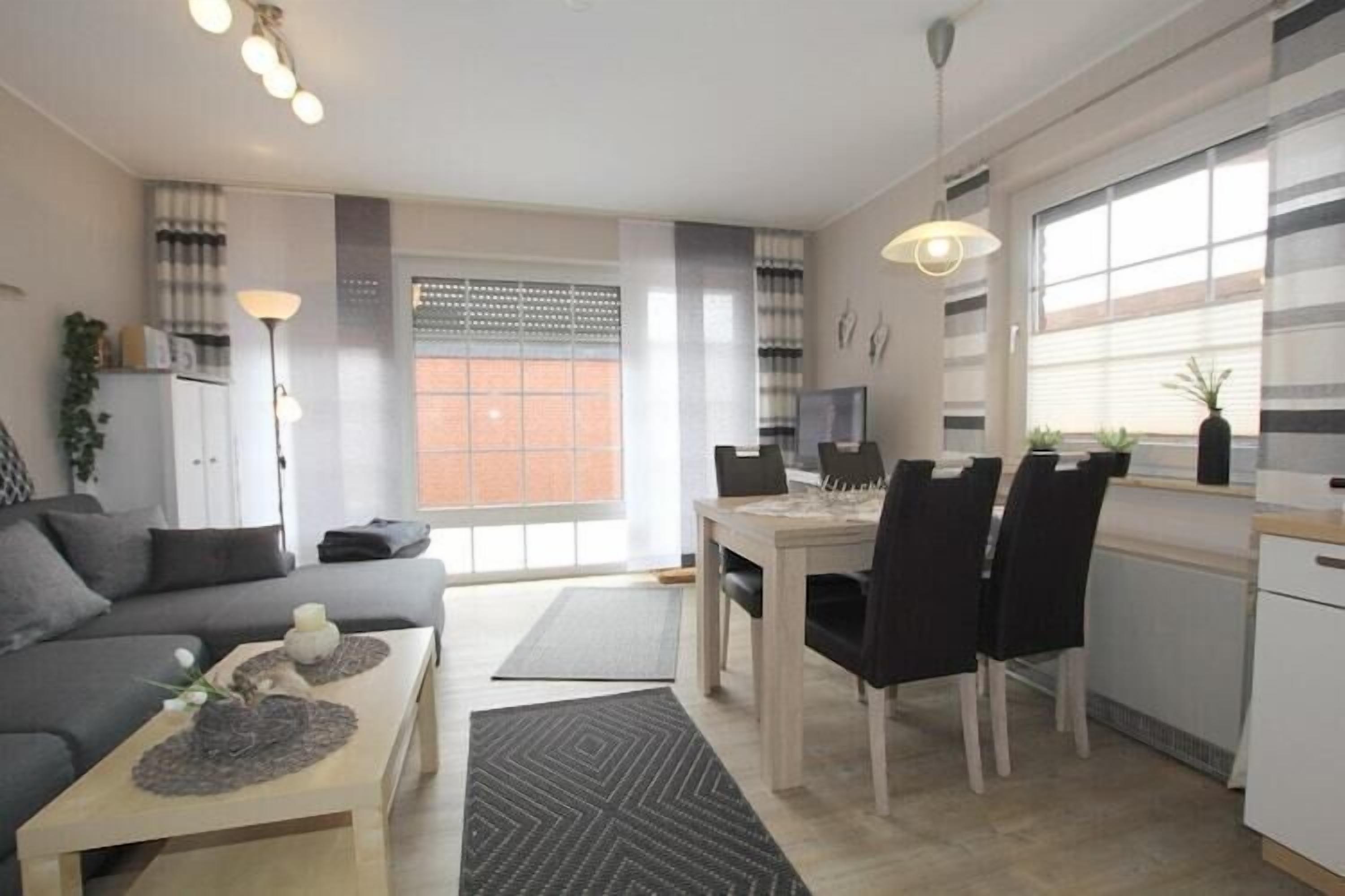 Ein modernes Wohnzimmer mit einer Couch, einem Couchtisch und einem Essbereich mit Stühlen und einem Tisch.