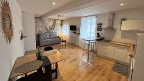 Un appartement moderne comprenant un coin repas, une cuisine et un espace de vie.