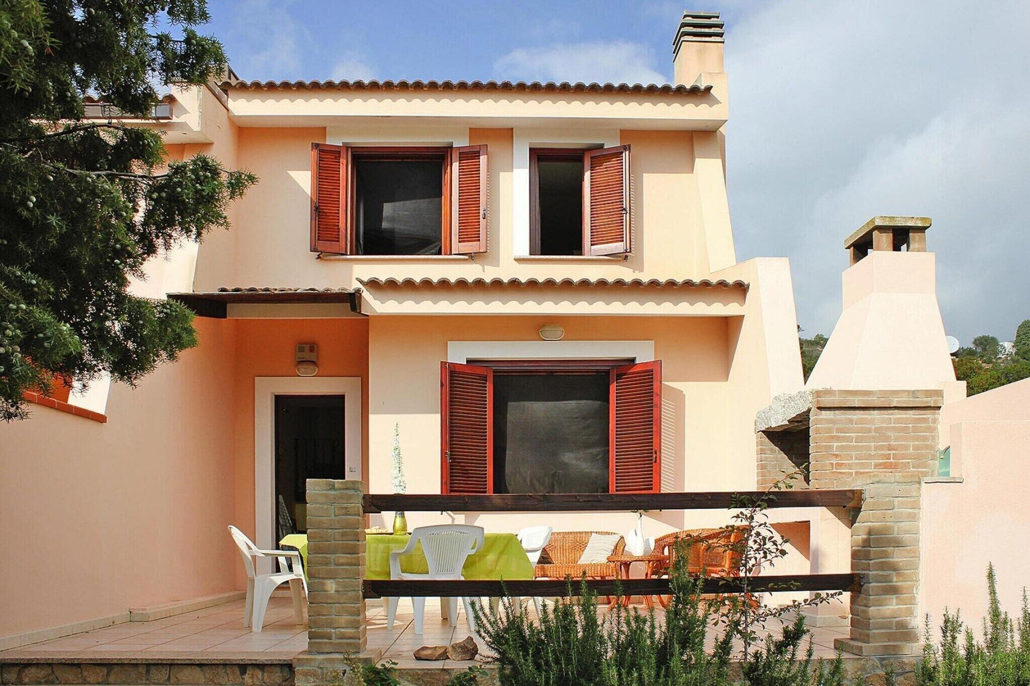 A two-story house with a balcony, a door, and a window with shutters.