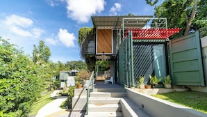 Une maison moderne avec un escalier menant à une terrasse en bois.